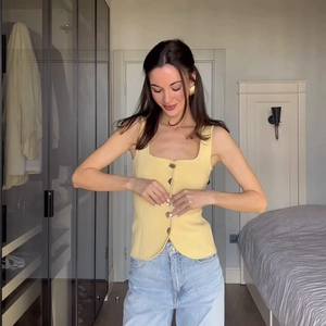 Chic light yellow sleeveless button-down vest paired with light blue wide-leg denim jeans