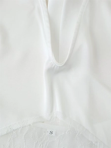 Detail of white deep V-neck top showing delicate lace trim and size S label