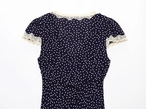 Detail of navy blue polka dot dress featuring delicate cream lace trim and back tie-up design