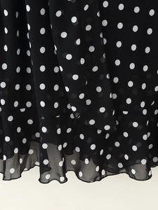 Macro shot of tiered black chiffon with white polka dot patterns and ruffled edges