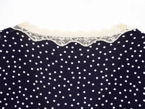 Detailed view of sweet lace splicing and polka dot pattern on the navy blue dress neckline