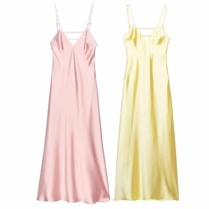 Detail of silk satin midi slip dresses in pink and yellow with elegant v-neckline