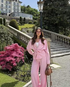 Outdoor shot of a pink safari-style shirt and high-waist wide-leg pants set for women