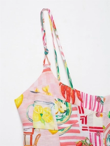 Close-up of pink button closure and floral fruit prints on summer camisole top