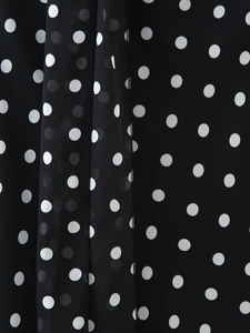 Detail shot of the polka dot fabric showing the fine stitching and texture of the dress