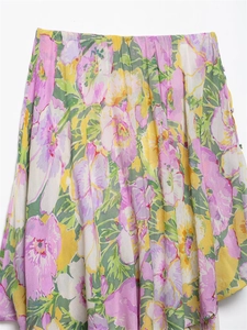 Detail of floral print maxi skirt featuring elastic high waist and decorative buttons