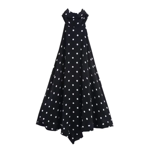 Dettaglio dell'elegante abito allacciato al collo a pois bianchi e neri in tessuto fluido