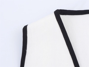 Close-up of the V-neckline with black trim on a white linen blend sleeveless summer dress