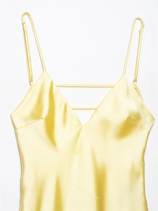 Detail of light yellow satin midi dress featuring thin straps and V-neckline straps