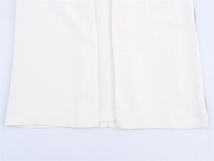 Close-up of the smooth hem on white linen blend dress showing fine fabric texture