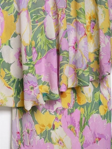 Macro detail of layered floral ruffles on a bright floral print summer dress fabric