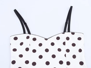 Detailed view of polka dot top with adjustable straps and wavy lace neckline