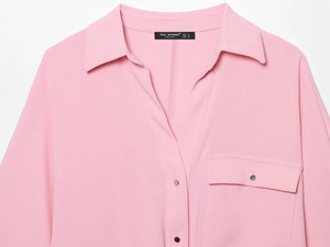 Close-up of pink long-sleeve safari shirt with silver buttons and crepe fabric texture