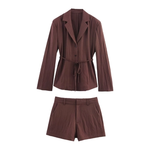Detail of chocolate brown striped blazer set showing fabric texture and tie-waist detail