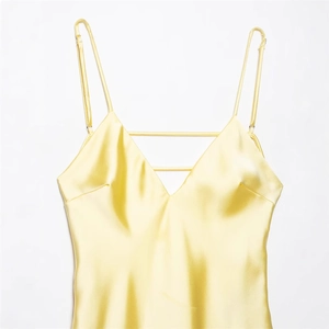 Elegant yellow satin midi dress with spaghetti straps and a decorative V-neckline