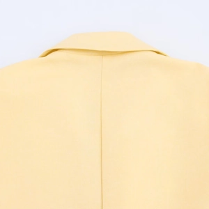 Pale yellow blazer featuring a minimalist lapel collar and clean back seam detail
