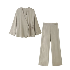 Détail du haut cache-cœur vert clair et du pantalon large à texture plissée fine