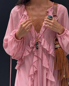 Detail of pink chiffon dress with tiered ruffles, V-neck, and bohemian accessories