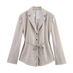 Detailed close-up of light grey pinstripe blazer featuring peak lapels and waist tie belt