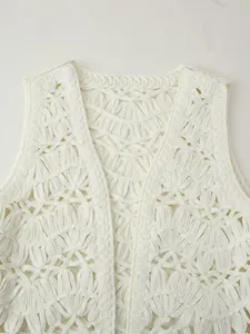 Close-up of white knit hollow waistcoat with shell decor and floral crochet texture