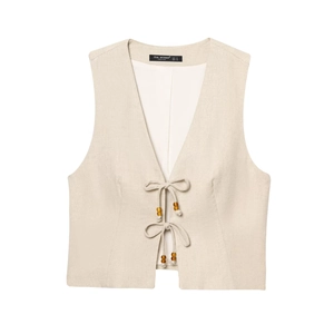 Detail of linen vest with deep V-neck and decorative wooden bead ties on beige fabric