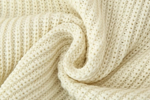Detailed macro shot of premium cream-colored chunky ribbed knit fabric texture
