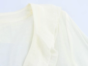 Detailed close-up showing the layered ruffle design and texture of the cream chiffon shirt