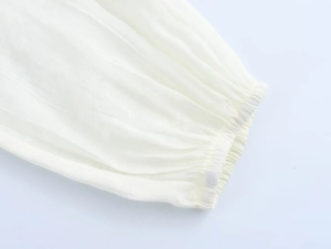Detail of elegant white chiffon shirt showing elastic ruffled cuffs and sheer fabric texture