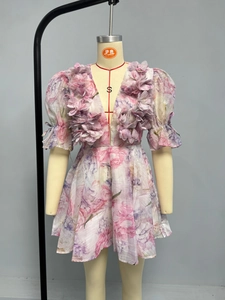 Détail de pétales 3D sur le décolleté en V d'une robe d'été fleurie à manches bouffantes