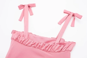 Détail des bretelles à nœuds réglables et de l'encolure plissée sur ce débardeur rose