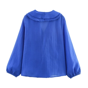 Detail of royal blue chiffon shirt with layered ruffle collar and lantern sleeves texture
