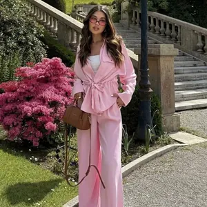 Chic pink two-piece safari style set with belted shirt and high-waist wide-leg pants