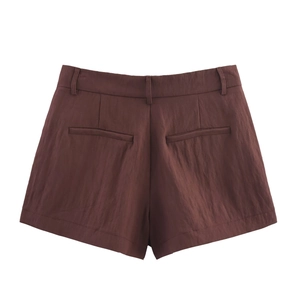 Detail of high-waist brown shorts with back welt pockets and textured fabric finish