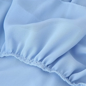 Detailed close-up of light blue chiffon fabric with neat stitching and fine texture