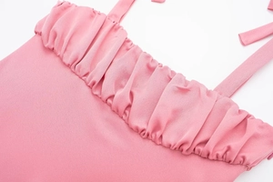 Détail du haut caraco rose avec texture plissée et fines bretelles pour femmes