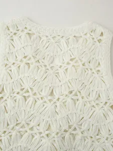 Detailed close-up of intricate white crochet hollow out floral knit pattern on vest