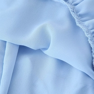 Detail of light blue chiffon fabric with ruffled edges and fine stitching craftsmanship