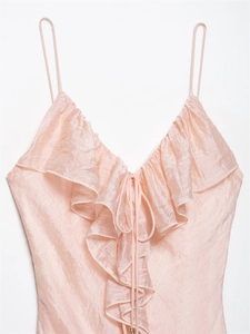 Detail of pink silk-like camisole with ruffled V-neckline and elegant gold bead drawstrings
