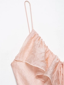 Detail of silk-like pale pink dress showing ruffled neckline and thin spaghetti straps