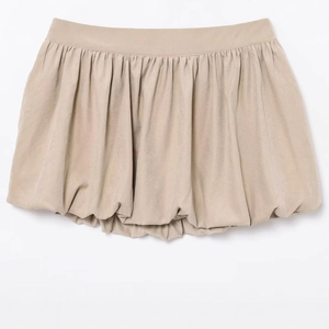 Vue à plat d'une mini-jupe boule beige élégante avec plis et ceinture large