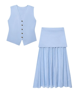 Détail d'un gilet en tricot bleu clair à boutons dorés et jupe plissée en tulle assortie