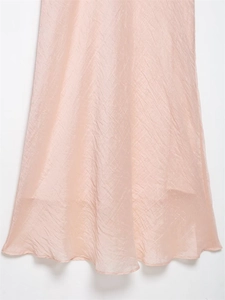 Detail of elegant light pink pleated fabric with soft texture and subtle sheen on hem
