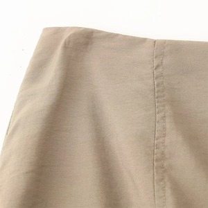 Détail de jupe à paillettes kaki montrant la coupe de taille et coutures précises