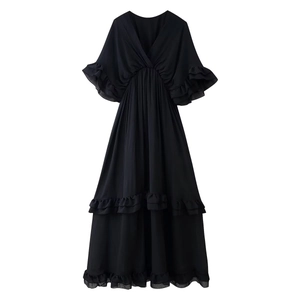Dettaglio dell'abito nero in chiffon con scollo a V, volant e gonna a balze a strati