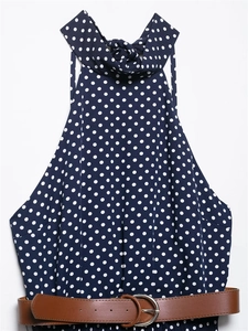 Dettaglio dell'abito blu navy a pois con scollo all'americana e cintura marrone