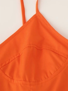 Close-up of bright orange camisole dress showing curved chest stitching and strap detail