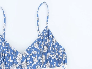Detail of blue and white floral pattern with pleated fabric texture on a summer dress