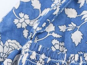 Detail of blue floral patchwork dress showing smocked fabric and adjustable strap