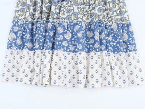 Detail of layered bohemian floral patchwork dress with blue and yellow floral print patterns