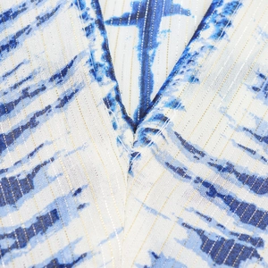 Detailed close-up of V-neckline featuring blue tie-dye fabric with gold metallic thread